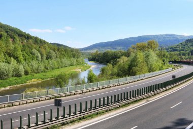 Yüksek peyzaj değeri olan bölgelerden geçen çok şeritli bir yol. Polonya, Myslenice yakınlarındaki otoyol..