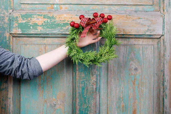 女人手里拿着一个传统的圣诞花环 上面用的是苏打树枝 红球和缎带 一步一步 — 图库照片