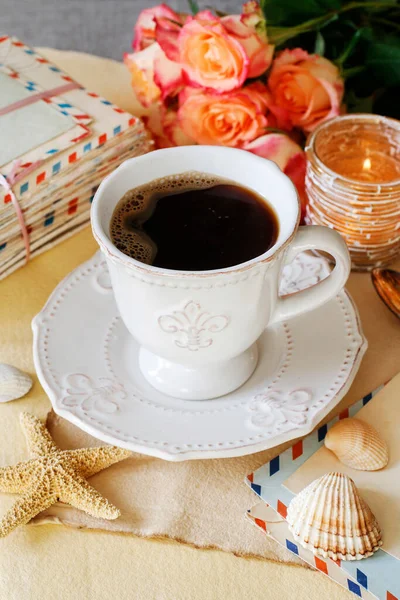 Cup of coffee, roses and vintage letters on the table. Retro style