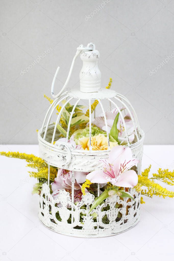 Floral arrangement with roses, alstroemeria and solidago flowers inside a vintage bird cage. Step by step, tutorial