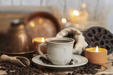 Masada çiğ taneli bir fincan kahve ve jüt çuvalı. Dinlenme zamanı.