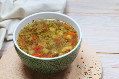 Beyaz ahşap masada bir kase sebze çorbası. Yemek tabağı.