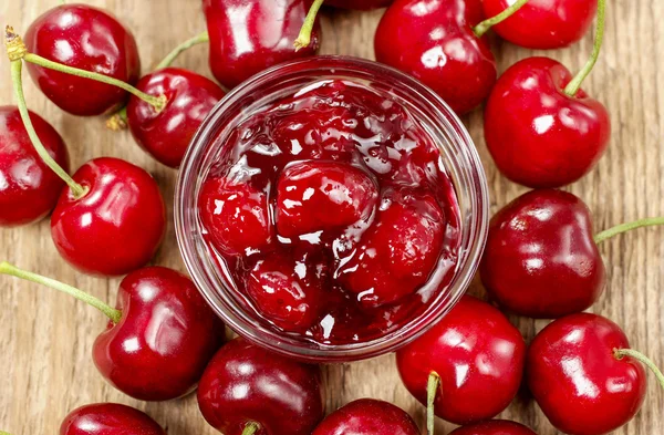 Bol de confiture de cerises sur table en bois — Photo