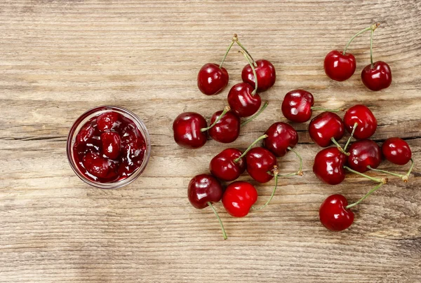 Bowl of cherry jam on wooden table — Stock Photo, Image