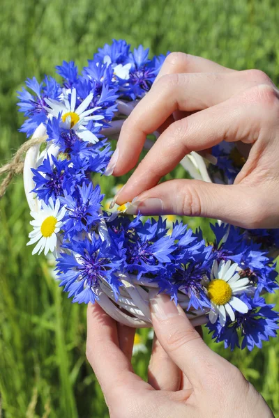 White wicker wreath decorated with cornflowers and chamomiles — Stock Photo, Image