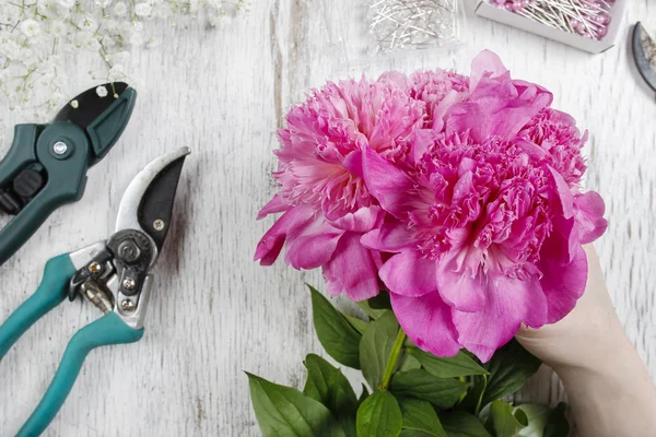 Florista no trabalho. Mulher fazendo mola decorações florais de rosa — Fotografia de Stock