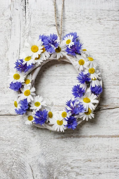 White wicker wreath decorated with cornflowers and chamomiles — Stock Photo, Image
