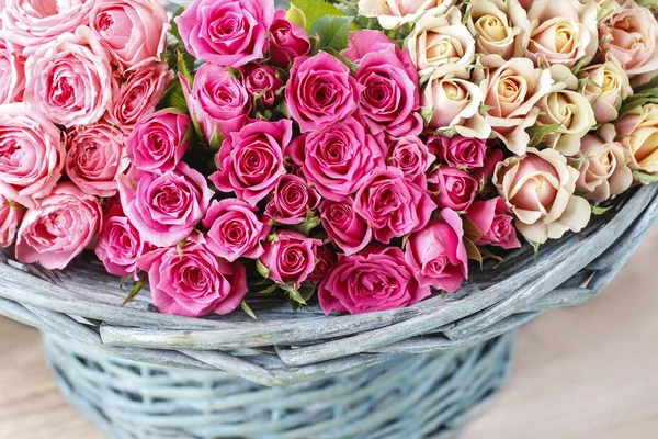 Růžové růže v tyrkysové proutěný koš — Stock fotografie