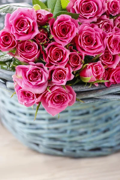 Pink roses in turquoise wicker basket — Stock Photo, Image