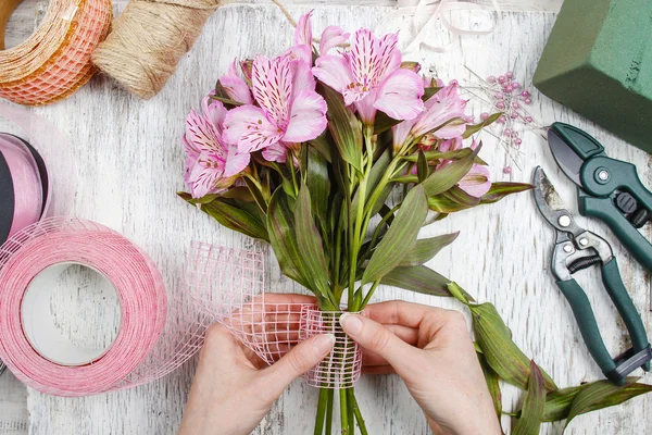Флорист на роботі: жінка організовує букет з квітів альстромерії — стокове фото