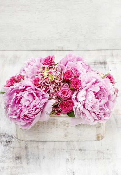 Pink peonies and roses in wooden box. — Stock Photo, Image