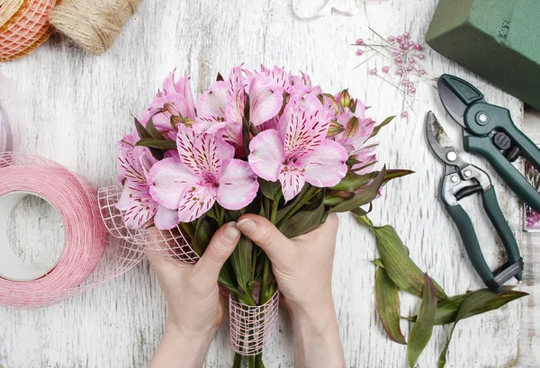 Fiorista al lavoro: donna che organizza bouquet di fiori di alstroemeria — Foto Stock