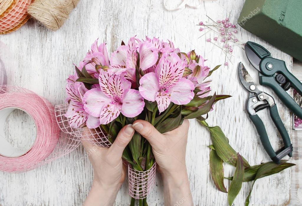 Florist at work: woman arranging bouquet of alstroemeria flowers