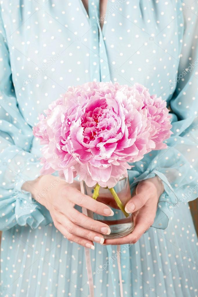 Woman holding bouquet of pink peonies