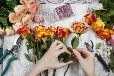 Çiçekçi iş başında. Turuncu gül buket düğün yapma kadın