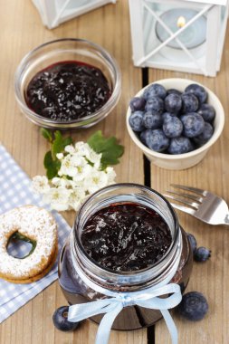 Böğürtlenli reçel kavanoz mavi yay ile dekore edilmiştir.