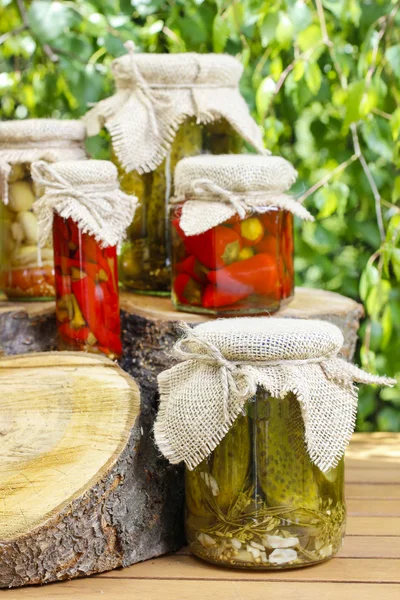 Jars of preserves on wooden table in the garden — Stock Photo, Image