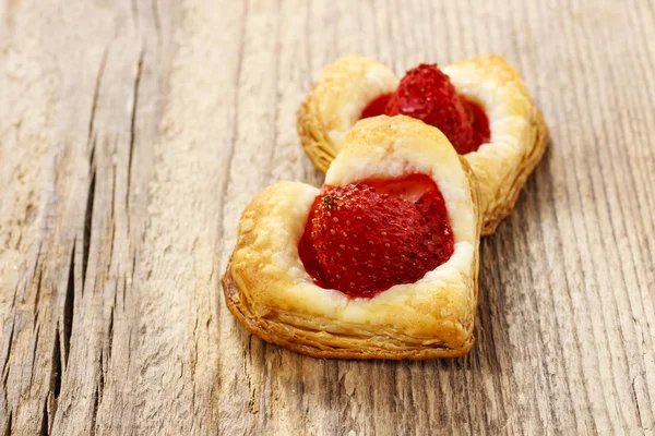 Puff pastry cookies in heart shape filled with strawberries. — Stock Photo, Image