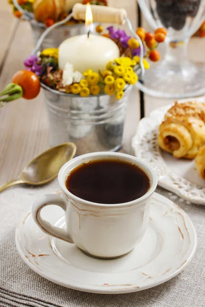 Breakfast table: cup of coffee and buns with chocolate — Stock Photo, Image