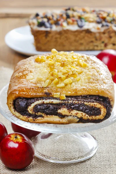 Torta di semi di papavero su supporto torta di vetro sotto ramo di abete — Foto Stock