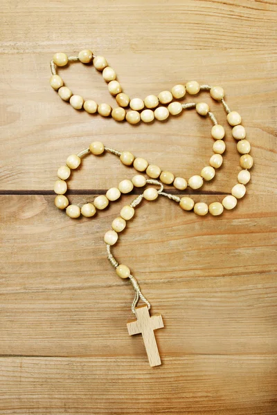 Rosary on wooden table — Stock Photo, Image