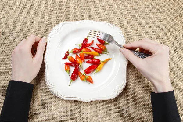 배고픈 여자 먹는 레드 핫 칠리 페퍼스입니다. 적응의 상징 — 스톡 사진