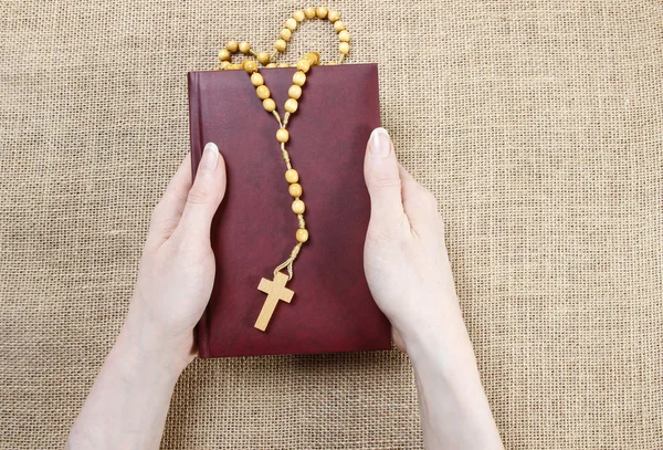 Kobieta trzyma Pismo Święte i różaniec drewniany — Zdjęcie stockowe