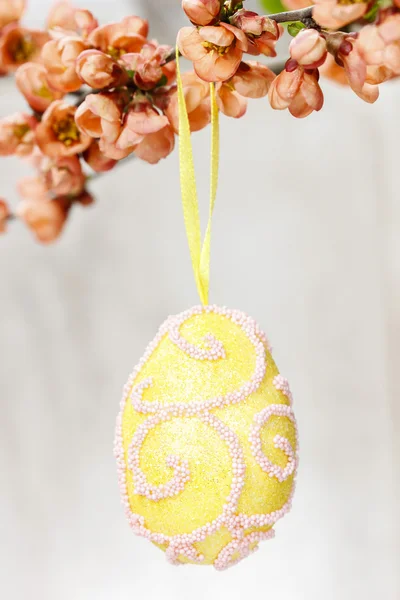 Huevo de Pascua en rama de melocotón en flor — Foto de Stock