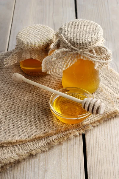 Jar of honey on wooden table — Stock Photo, Image