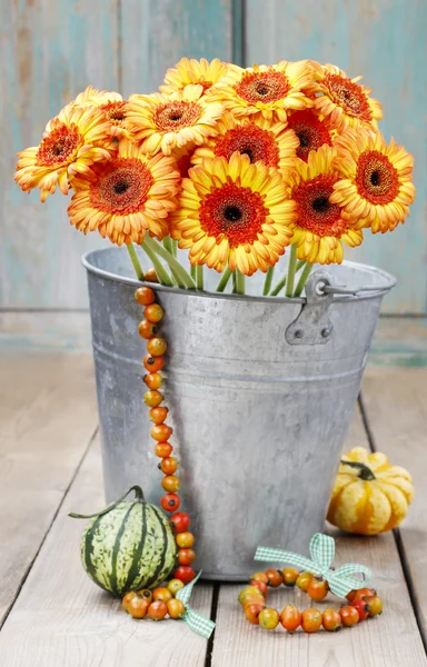 Strauß orangefarbener Gerbera-Gänseblümchen im silbernen Eimer auf Holzlasche — Stockfoto