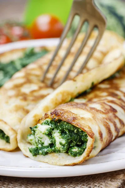 Mediterranean cuisine: crepes stuffed with cheese and spinach — Stock Photo, Image