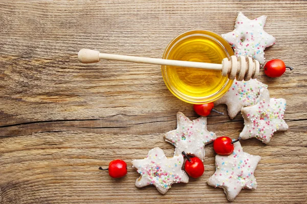 Пряничное рождественское печенье и миска меда на деревянном столе — стоковое фото