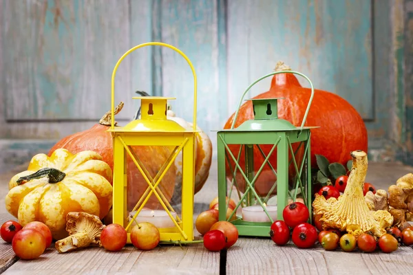 Bunte Laternen zwischen Herbstpflanzen auf Holztisch — Stockfoto