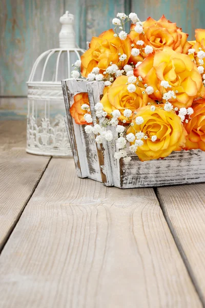 Bouquet of orange roses in a white wicker basket and vintage bir — Stock Photo, Image