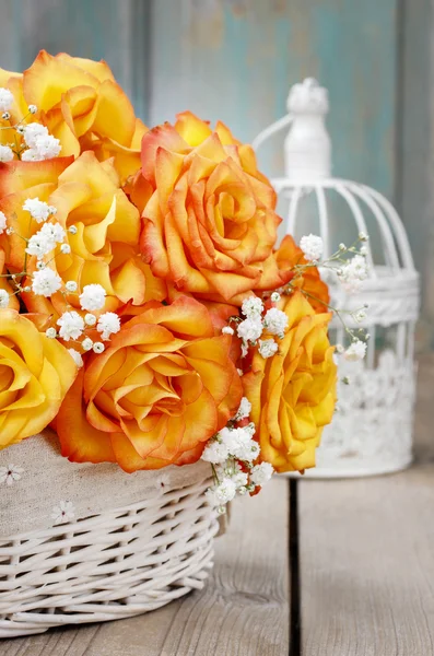 Bouquet di rose arancioni in un cesto di vimini bianco e bir vintage — Foto Stock