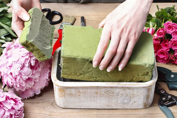 Floristería en el trabajo: mujer haciendo decoración floral de peonías rosadas — Foto de Stock