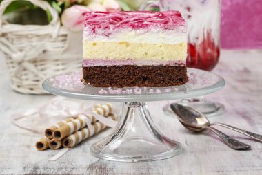 Bir cam pasta stand üzerine pembe krema ile katman pasta