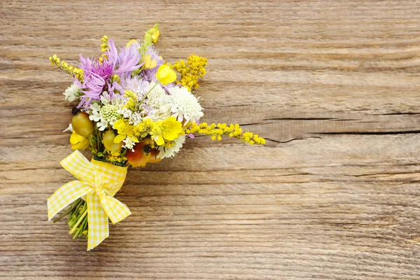 Ramo de flores silvestres sobre fondo de madera marrón — Foto de Stock