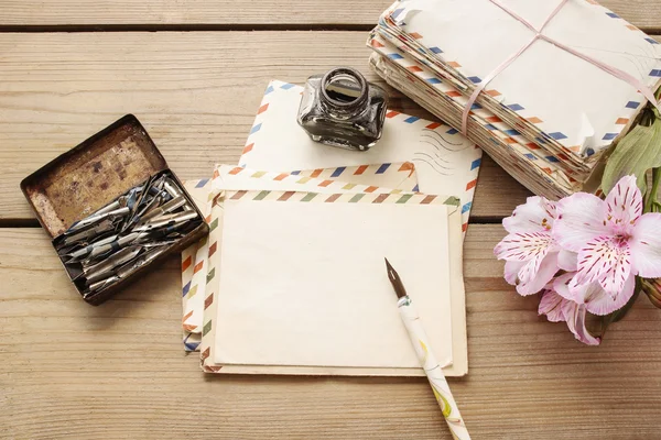 Package of vintage letters, pen and pink alstroemeria flowers — Stock Photo, Image