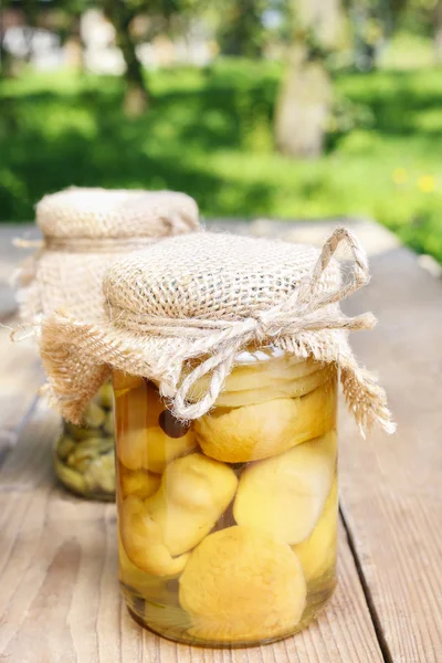 Jars of preserves on wooden table in the garden — Stock Photo, Image