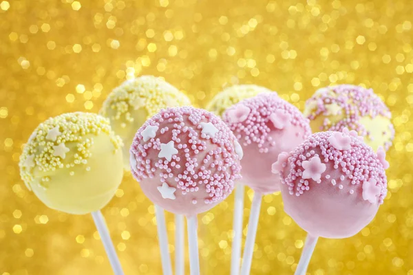 Rosa und gelbe Cake Pops mit Streusel verziert. — Stockfoto