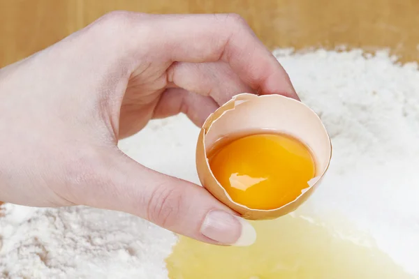 Mujer rompiendo huevos en cuatro para hacer masa de pan — Foto de Stock