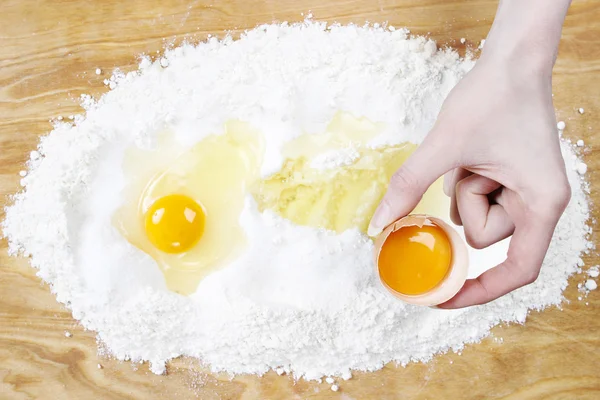 Mulher quebrando ovos em quatro para fazer massa de pão — Fotografia de Stock