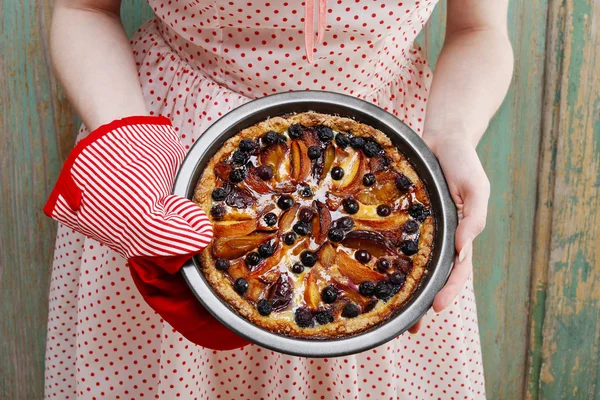 Woman holding fruit tart taken straight out of oven — Stock Photo, Image