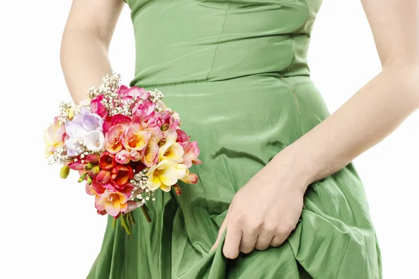 Giovane donna in abito verde che tiene bouquet di fresia colorata f — Foto Stock