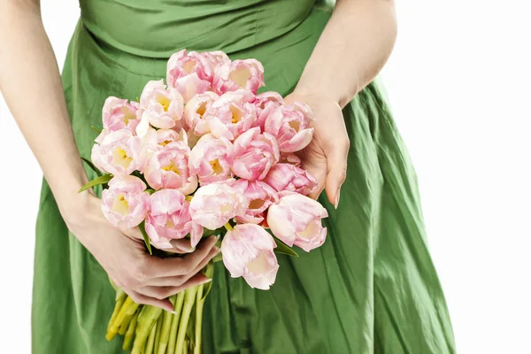 Giovane donna in abito verde che tiene bouquet di tulipani rosa — Foto Stock