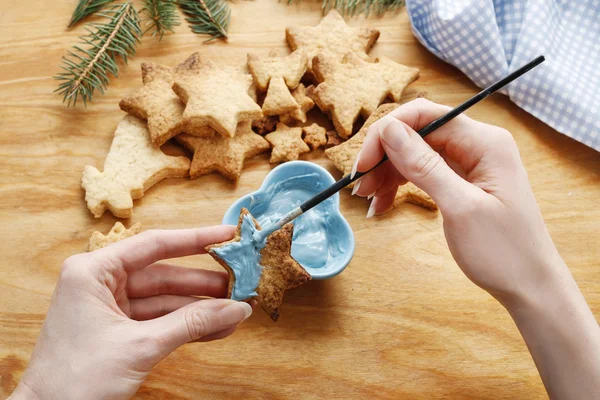 Decorar biscoitos de gengibre com glacê azul e branco . — Fotografia de Stock
