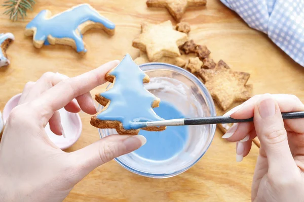 Decorating gingerbread cookies with blue and white icing. — Stock Photo, Image