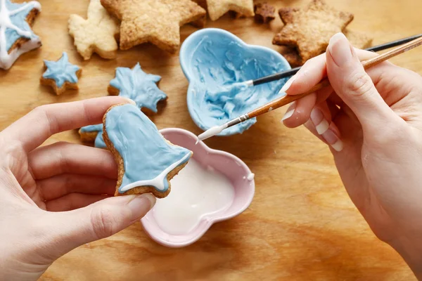 Decorar biscoitos de gengibre com glacê azul e branco . — Fotografia de Stock