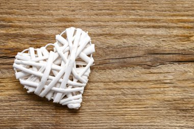 Kahverengi ahşap zemin üzerinde beyaz hasır kalp